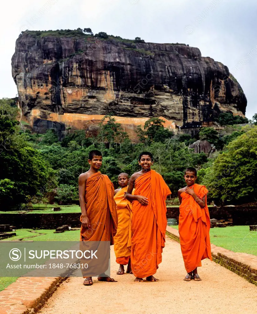 Monks standing in front of the Rock of Sigiriya, Lion Rock, column of rock of an eroded volcano, UNESCO World Heritage Site