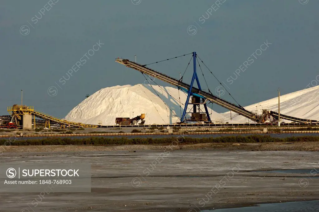 Heap of sea salt at the salt works Salins du Midi with an evaporation basin at front