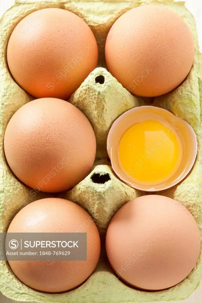 Eggs in egg carton, one egg open