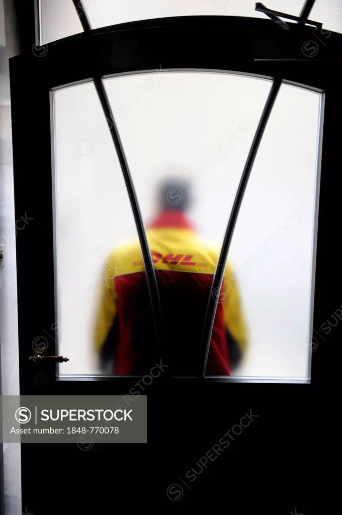 DHL parcels delivery driver is standing in front of a front door with frosted glass