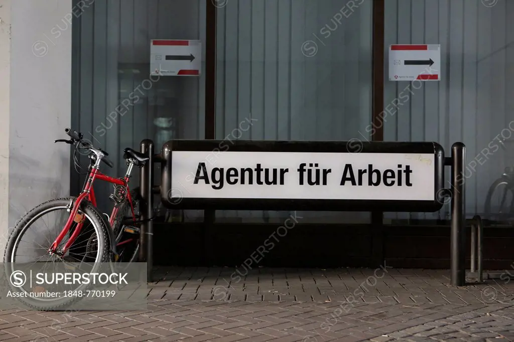 Bicycles parked beside the sign Agentur fuer Arbeit, German for Employment Agency