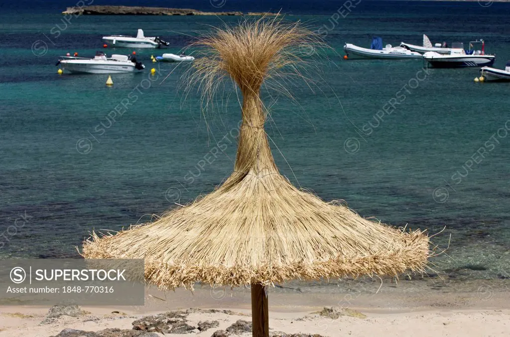 Straw parasol on the beach of Platja Es Trenc