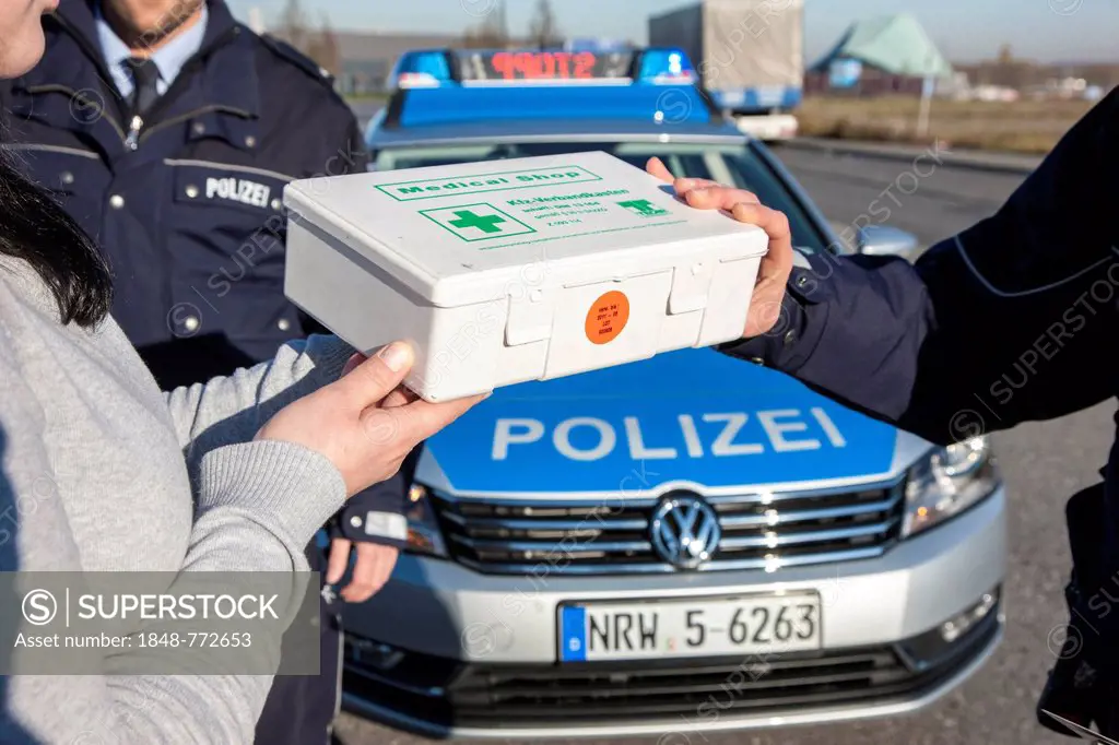 Policeman checking a first aid box during a traffic control