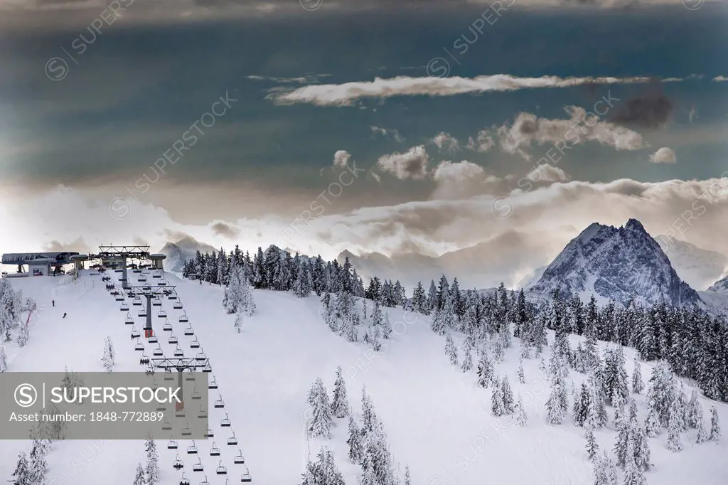 Chair lift on Eiberg Mountain in the Wilder Kaiser Ski World, summit of Grosse Rettenstein Mountain, 2366m, on the right