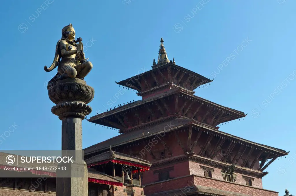 Statue of Garuda on Patan Durbar Square, a temple at the back