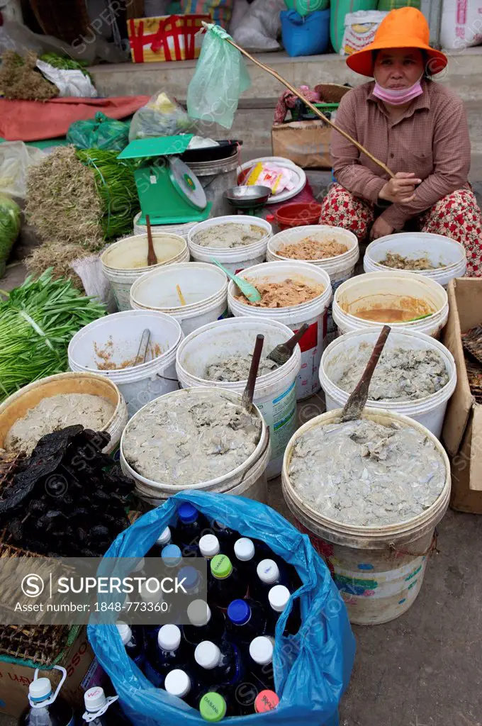 Woman selling fermented fish paste at a market