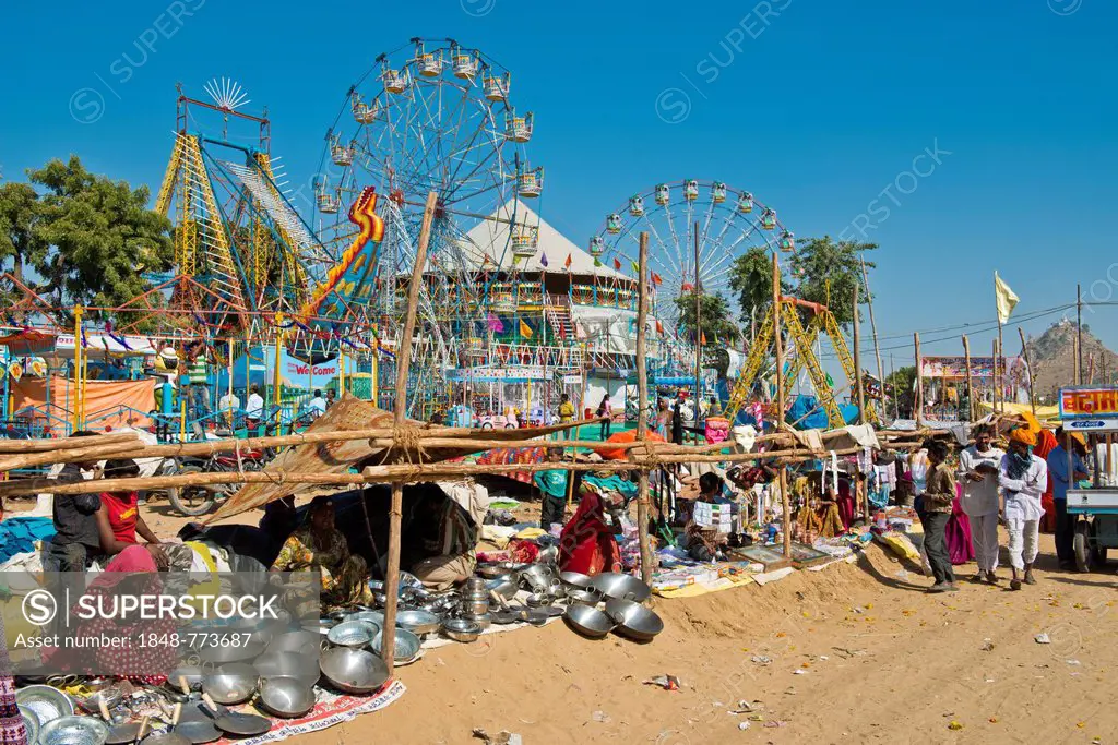 Stalls selling pots and Chapati pans, carnival with Ferris wheels at back, Pushkar Camel Fair
