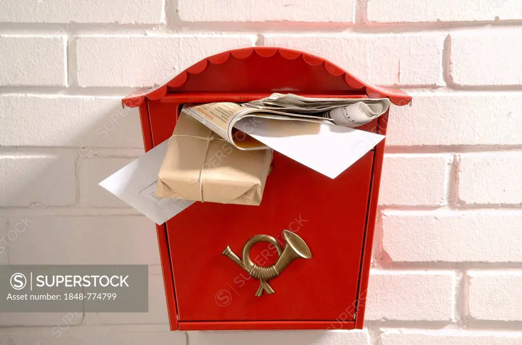 Red mailbox stuffed with letters and parcels