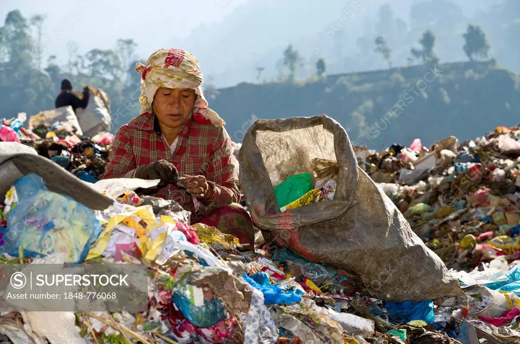 Woman sorting out garbage at Aletar garbage dump, earning 300-400 nepali rupees a day