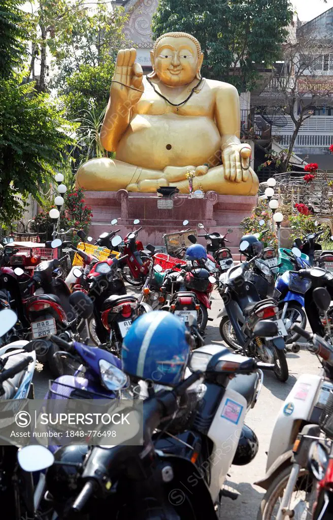 Parking lot for motor scooters in front of a large golden Buddha statue, Chiang Rai, Thailand, Asia
