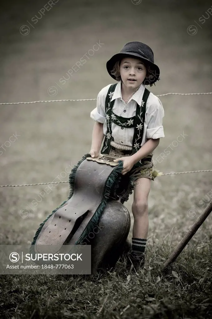 Young shepherd with a large bell during the Viehscheid cattle drive