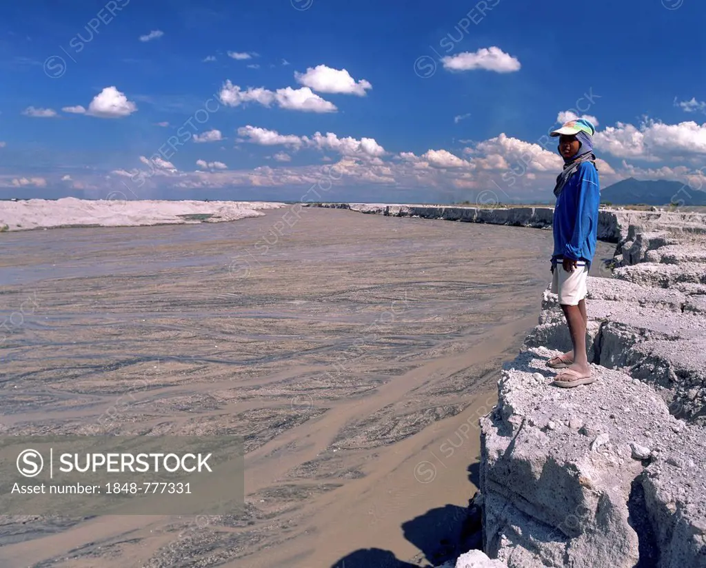Boy standing on the bank of a mudstream, Mt Pinatubo, lahar fields, lahar, pyroclastic flow