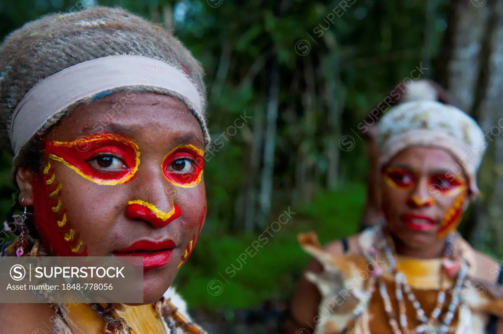 Women with colourful face paint are celebrating at the traditional Sing Sing gathering in the highlands