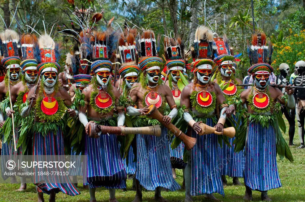 Men in colourfully decorated costumes with face paint are celebrating at the traditional Sing Sing gathering in the highlands