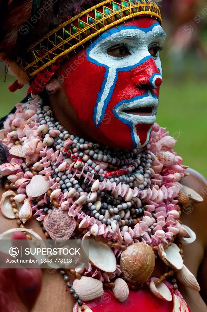 Woman in a colourfully decorated costume with face paint is celebrating at the traditional Sing Sing gathering in the highlands