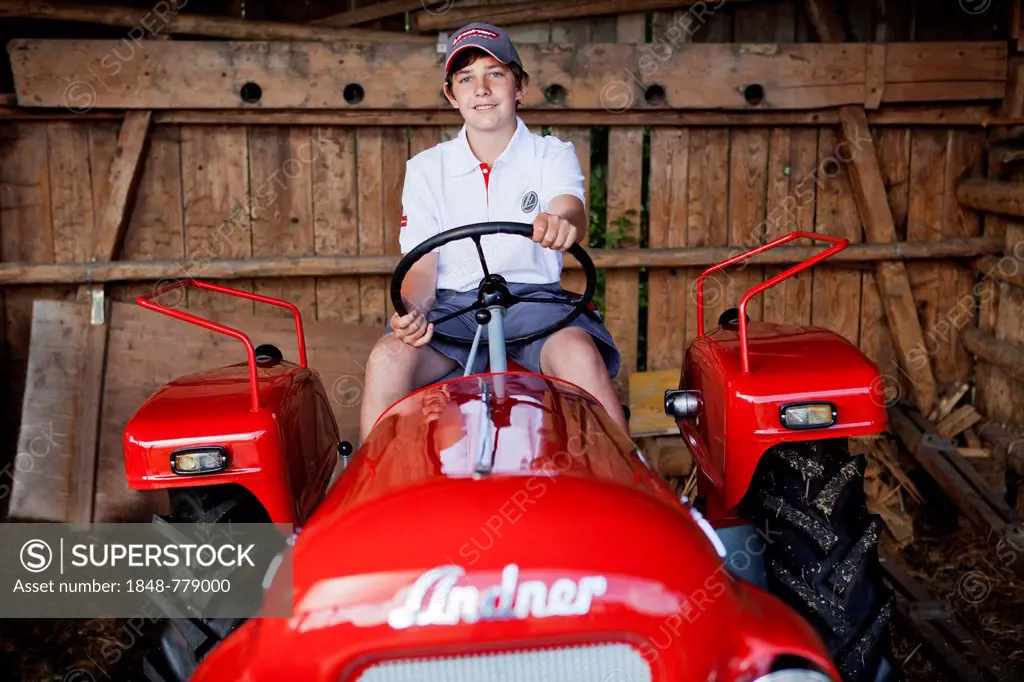 Boy sitting on a vintage tractor