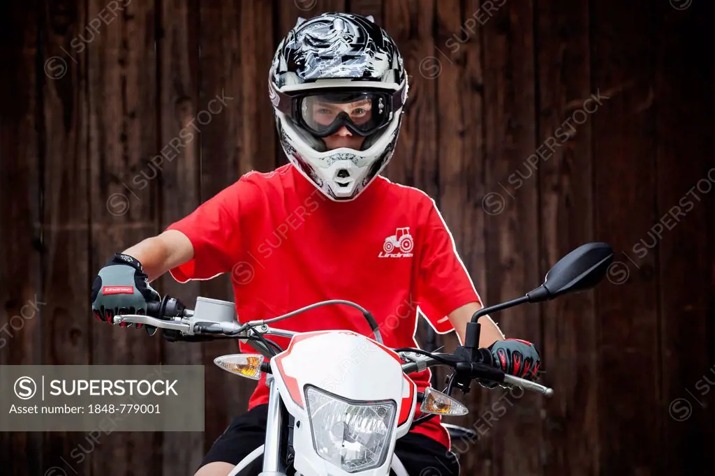 Boy wearing a helmet sitting on a motorcycle
