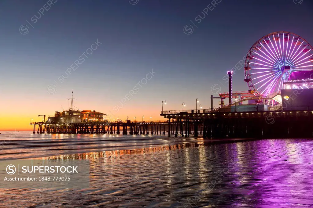 Ferris wheel at Pacific Park on the Santa Monica Pier and the beach in Santa Monica at dusk