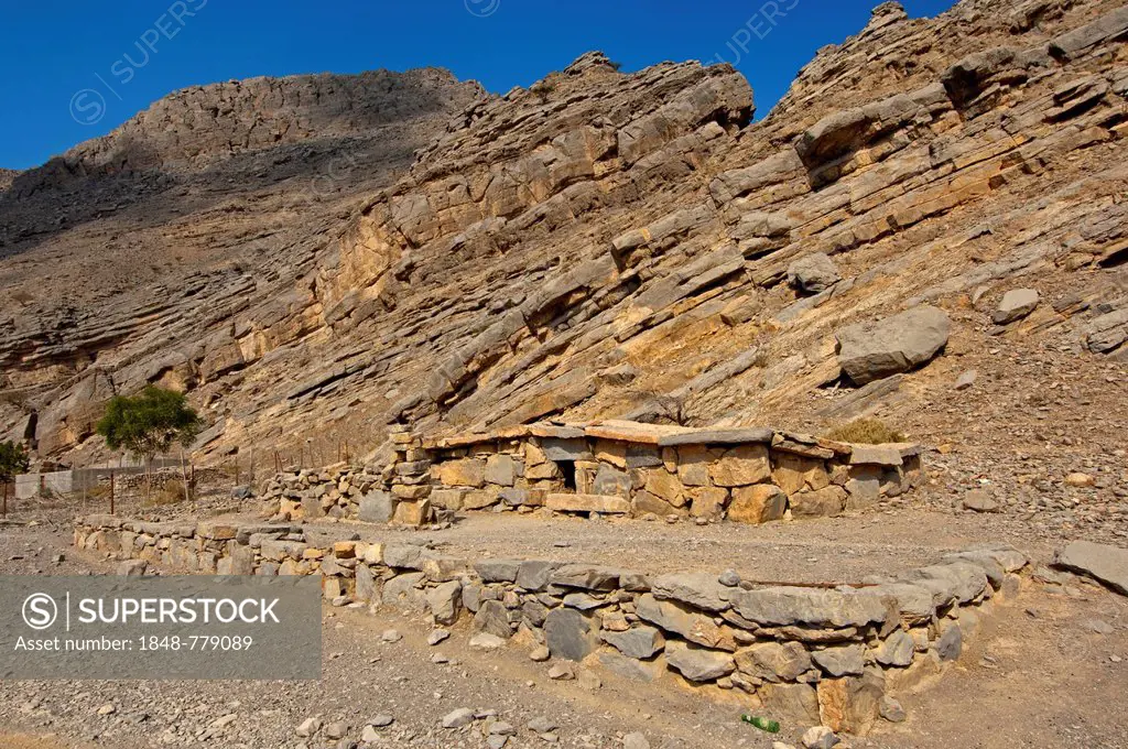 Bedouin stone house matching in colour and texture to the foot of a cliff in the mountains of Musandam