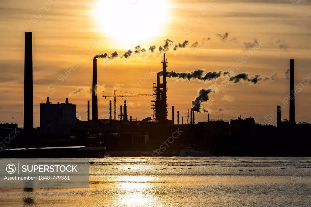 Industrial plant of Sachtleben Chemie GmbH, a manufacturer of specialty chemicals, on the Rhine River at sunset