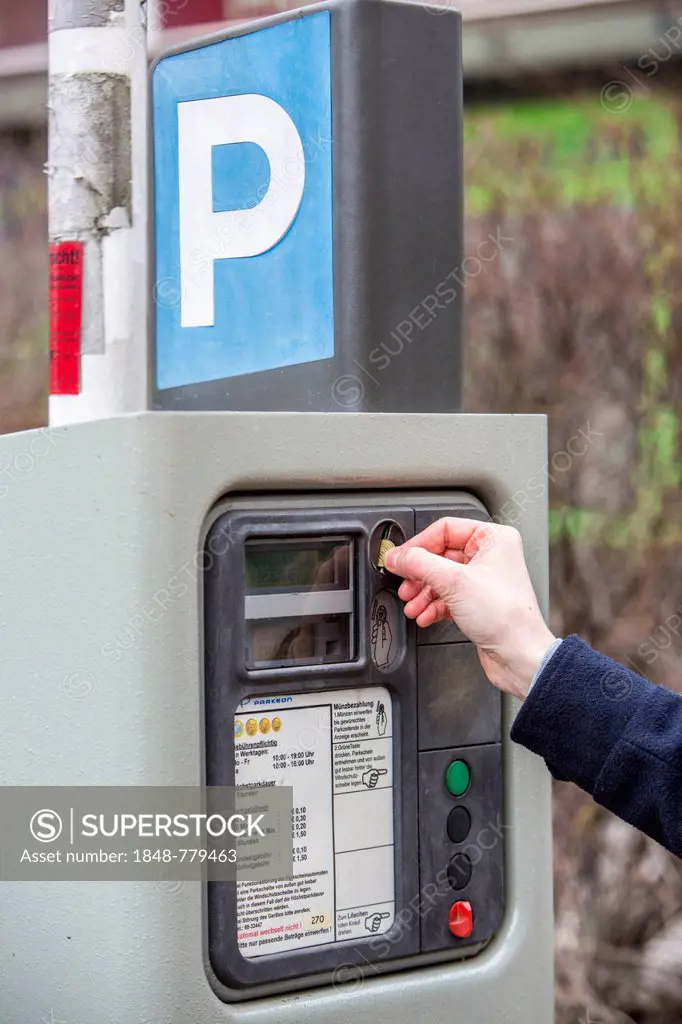 Woman purchasing a parking ticket from a parking ticket vending machine, inner-city public parking