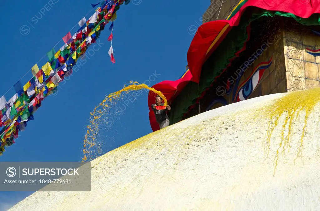 Worker renewing the yellow paint of Boudnath Stupa