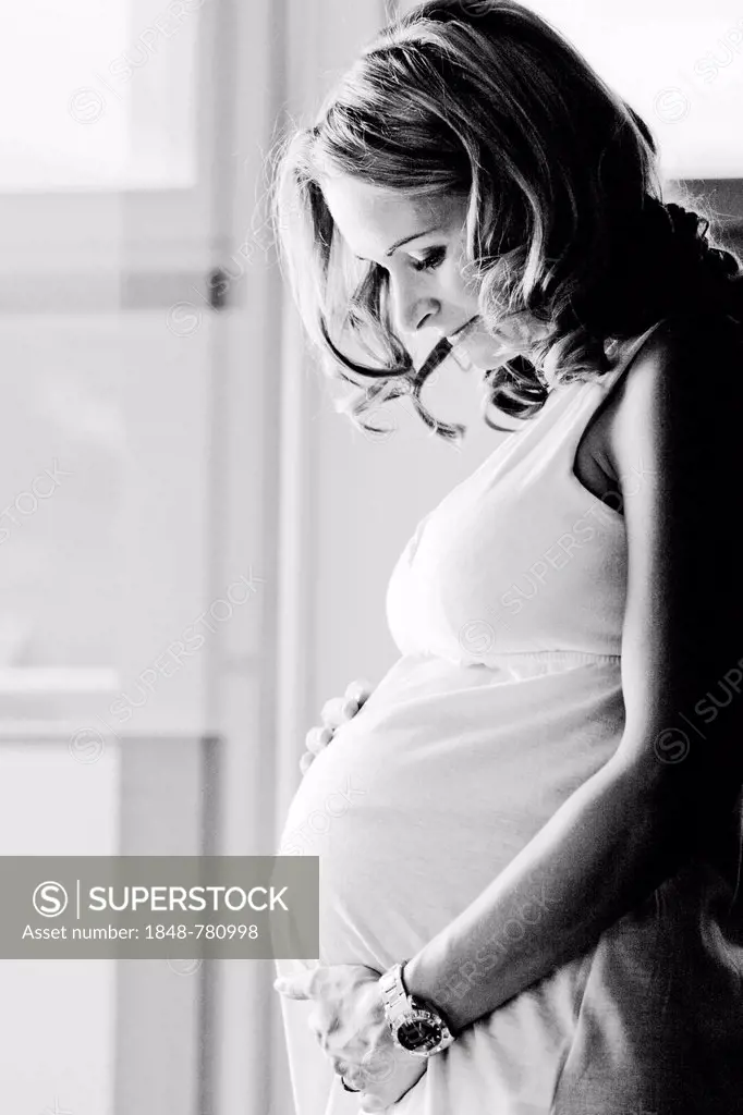 Pregnant woman looks at her baby bump
