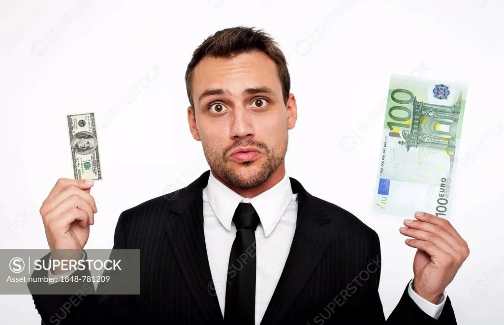 Frustrated young man wearing a suit holding a small 100 dollar bill and a large 100 euro banknote