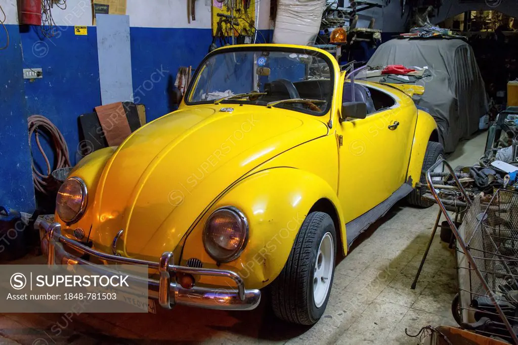 VW Beetle Cabrio, yellow, in a garage