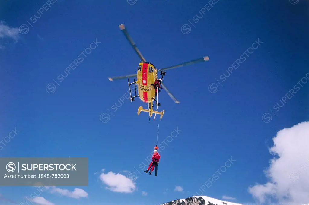 ADAC helicopter during a mountain rescue with a winch