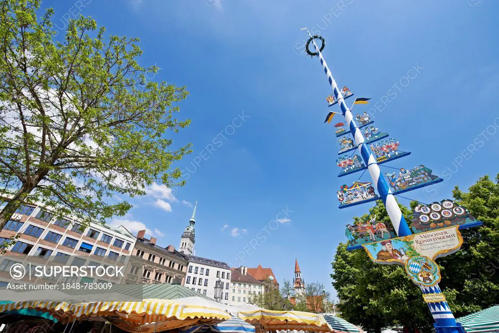Viktualienmarkt square with a maypole and the colourful umbrellas of the market stalls, St. Peter's Church and the Old Town Hall tower at the rear