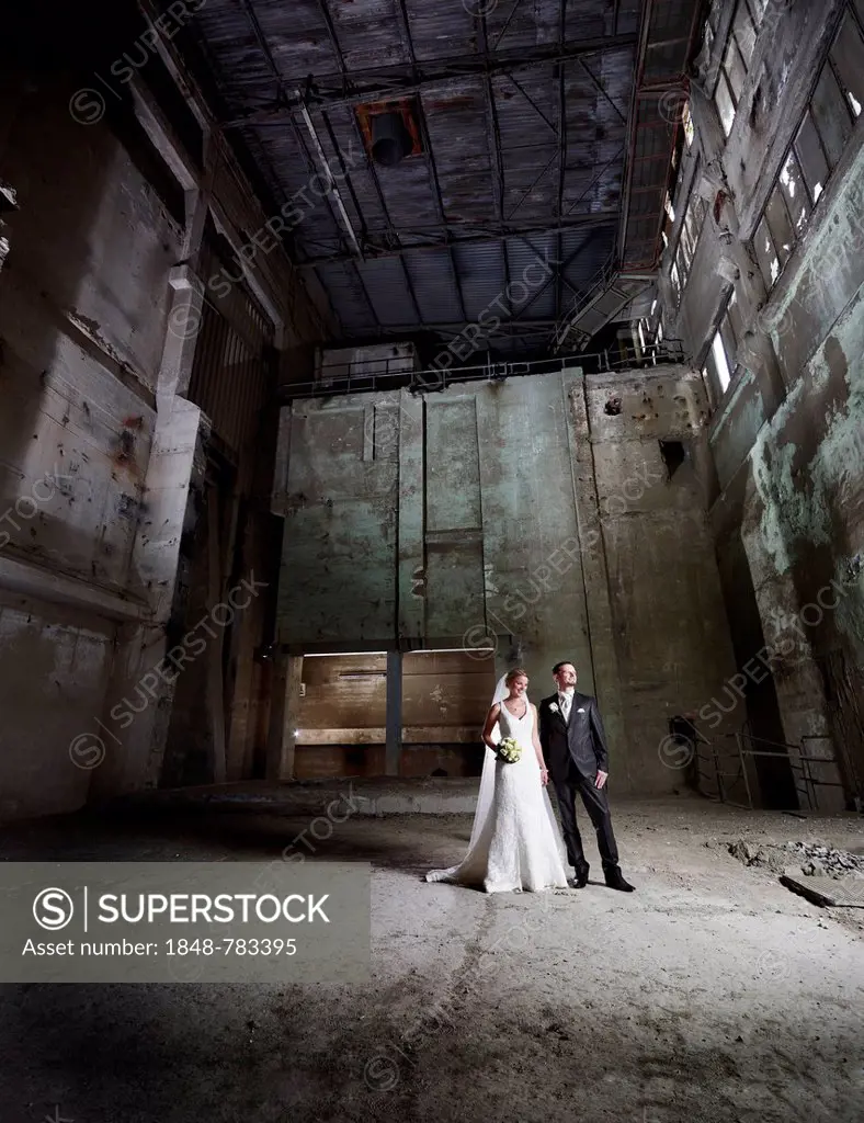 Bride and groom standing in an old industrial building