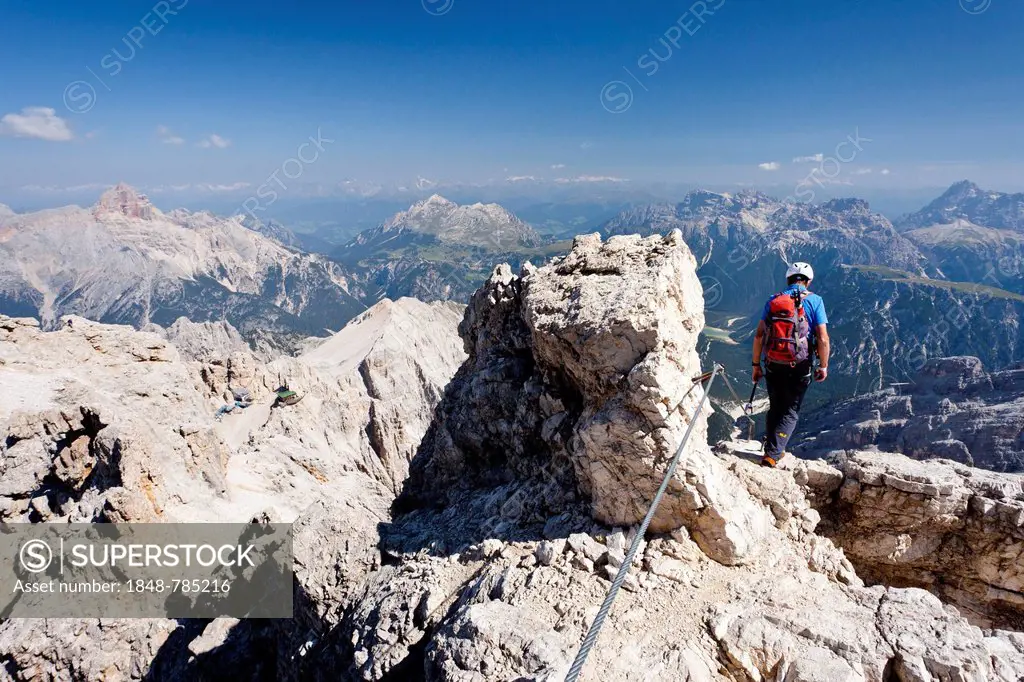 Mountain climber descending the Marino Bianchi climbing route on Monte Cristallo to the summit of Cristallo di Mezzo, Hohe Gaisl Mountain at the rear,...