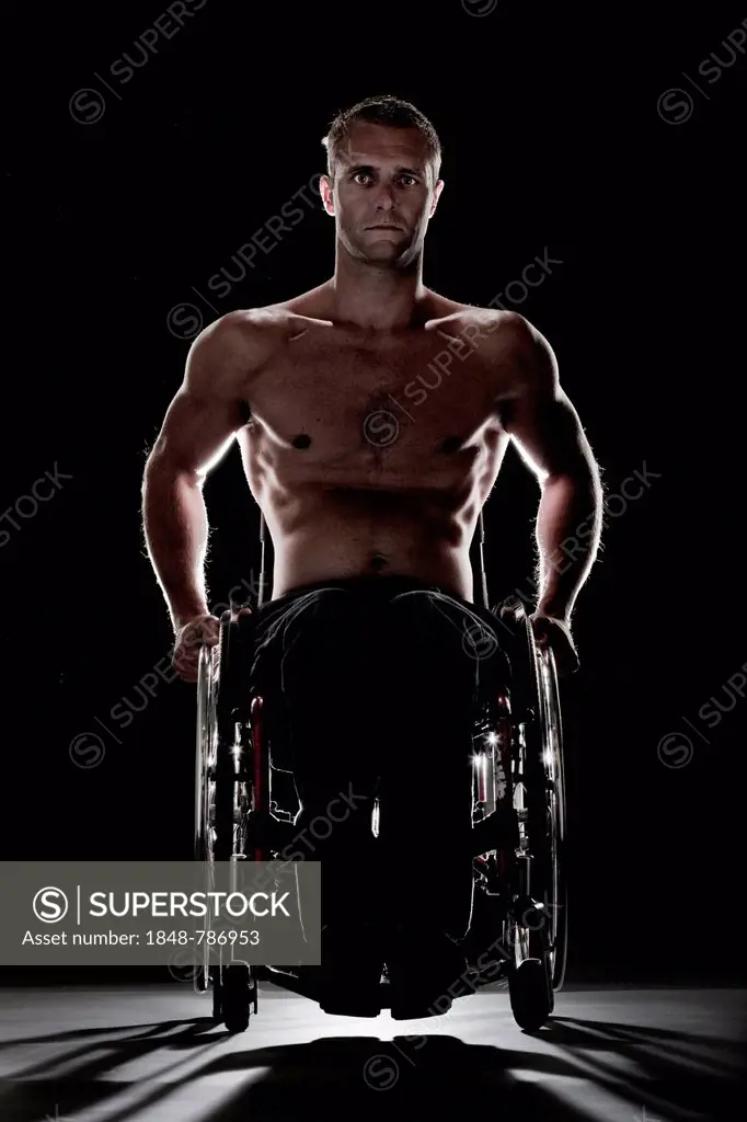 Muscular wheelchair user with a bare chest, feeling uneasy
