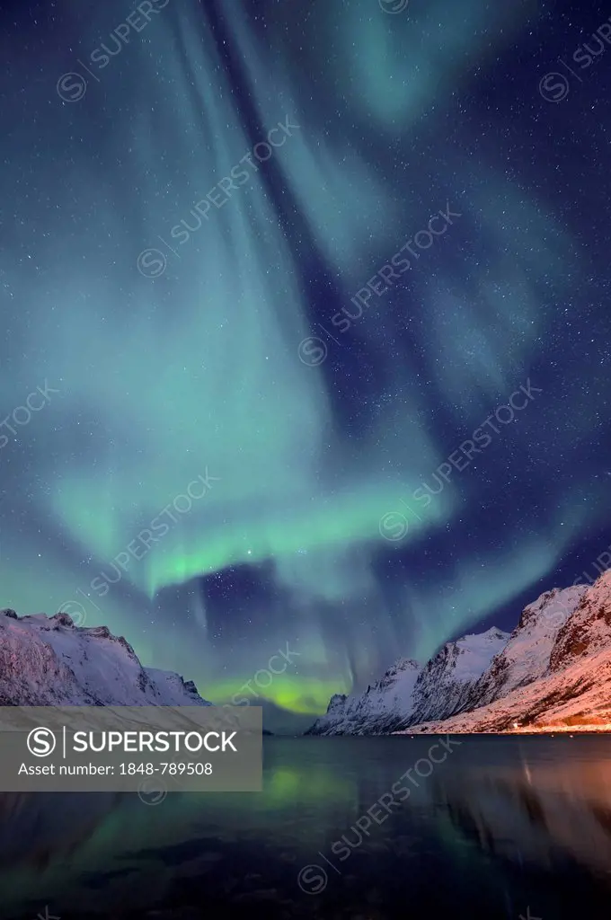Aurora over a fjord with snow-covered mountains