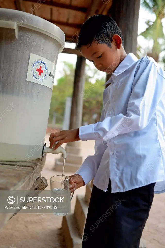 Boy drinking filtered water, the water filter has been distributed as part of a hygiene campaign from a charity