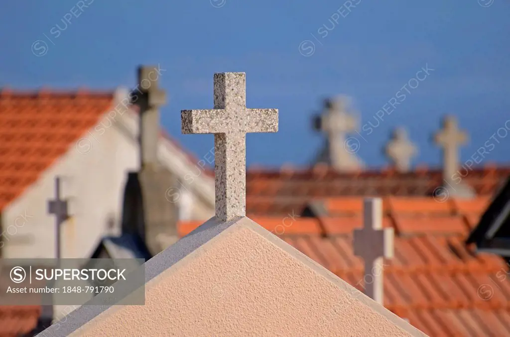 Crucifixes of the typical above-ground tombs in the cemetery of Ajaccio with the water of the mediterranean sea in the background. Ajaccio is the capi...