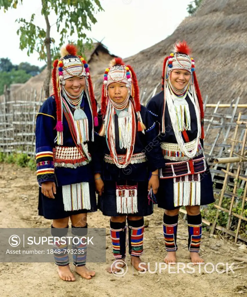 Three Akha girls in a mountain village, in traditional costume and headdress