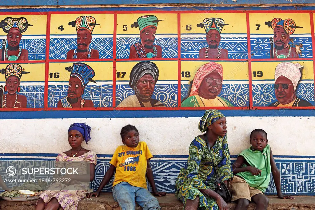 Boys and girls sitting in front of the row of ancestors on the Sultan's Palace of Foumban