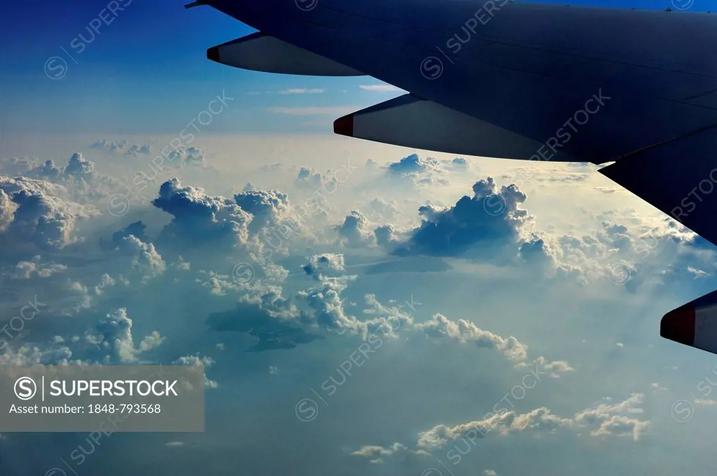 Wing of a plane with clouds