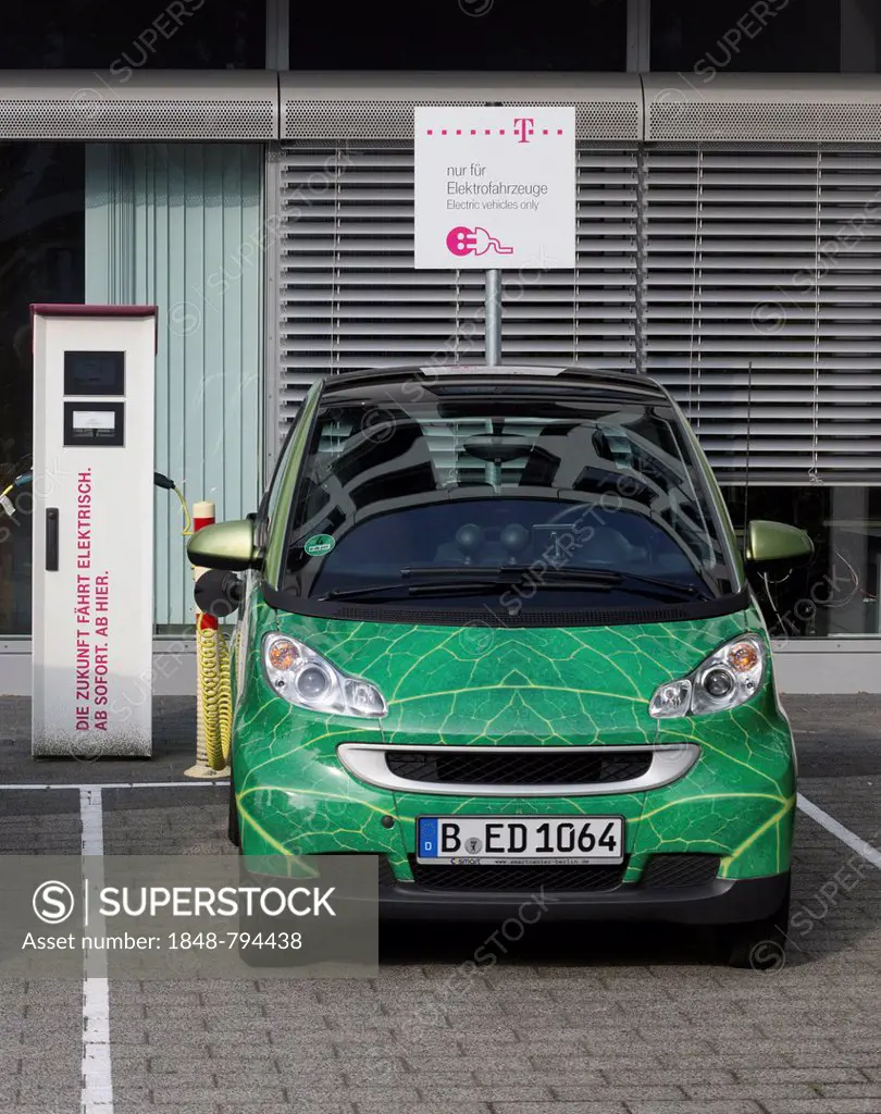 Electric car being charged in a charging socket at the front of the Telekom-Zentrale headquarters