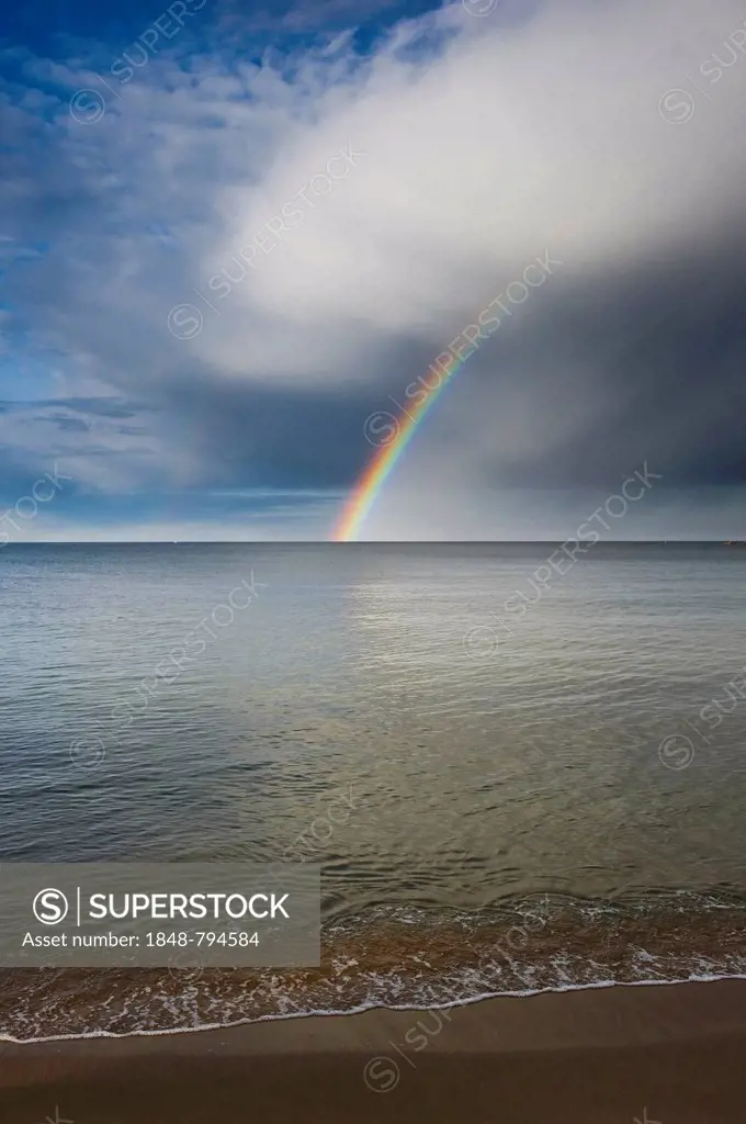 Sandy beach with rainbow over the sea
