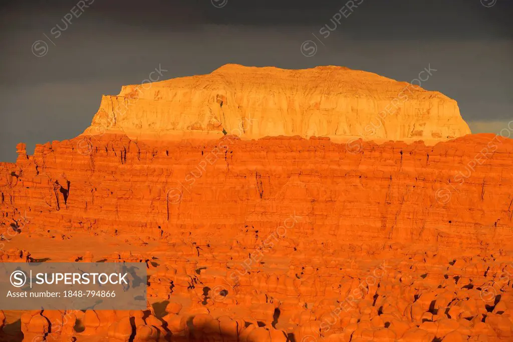 Wild Horse Mesa, eroded hoodoos and rock formations of Entrada Sandstone in the morning light, dark clouds at back