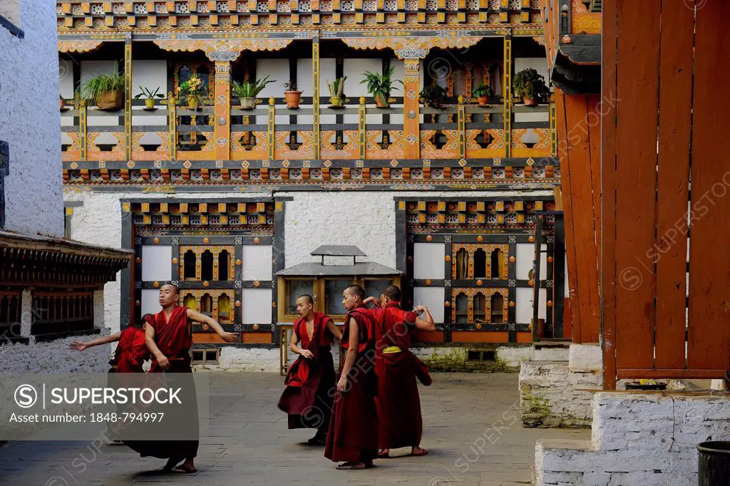 Group of young monks practicing a religious dance in the courtyard of Mongar Dzong fortress