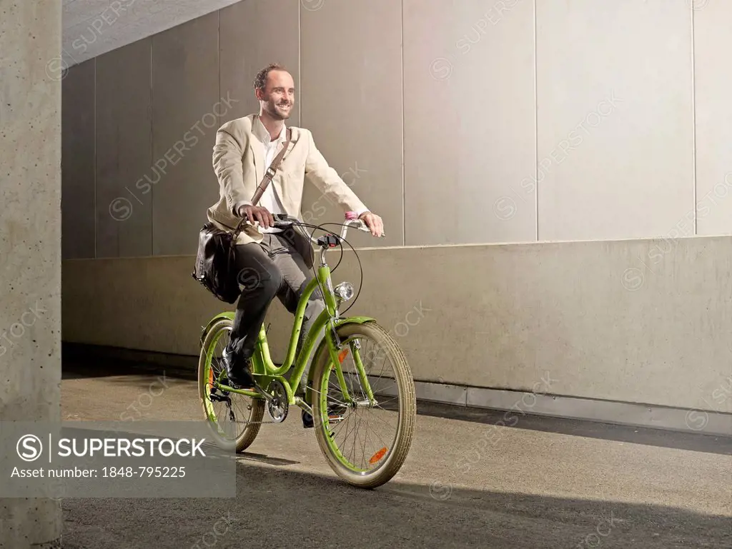 Man carrying a bag over his shoulder while riding a bicycle in the city