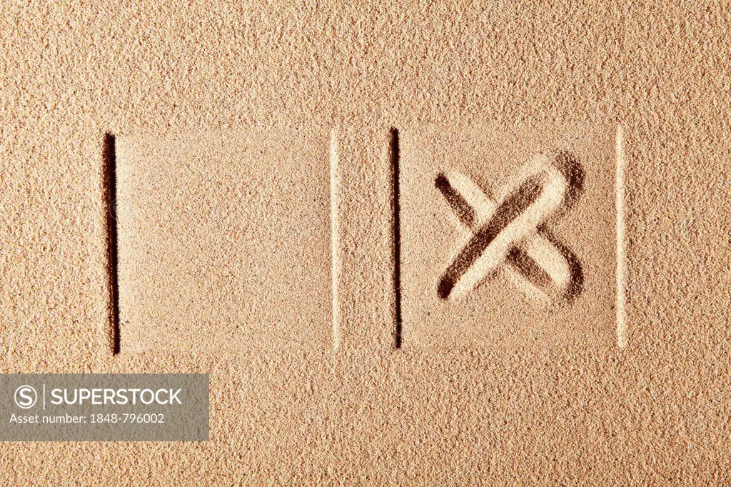 Two boxes, one with a cross, drawn in sand