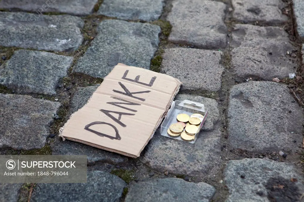 Paving stones, sign with the message Danke, German for Thanks, with coins in front, Cologne, North Rhine-Westphalia, Germany, Europe