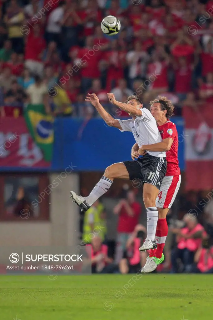 Emanuel Pogatetz, #4 Austria, and Miroslav Klose, #11 Germany, fight for the ball during the WC qualifier soccer game on September 11, 2012 in Vienna,...