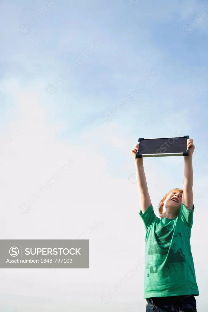 Boy holding a solar panel towards the sun