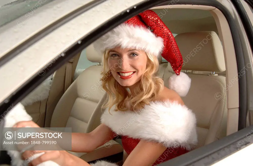 Sexy female Santa sitting in a car